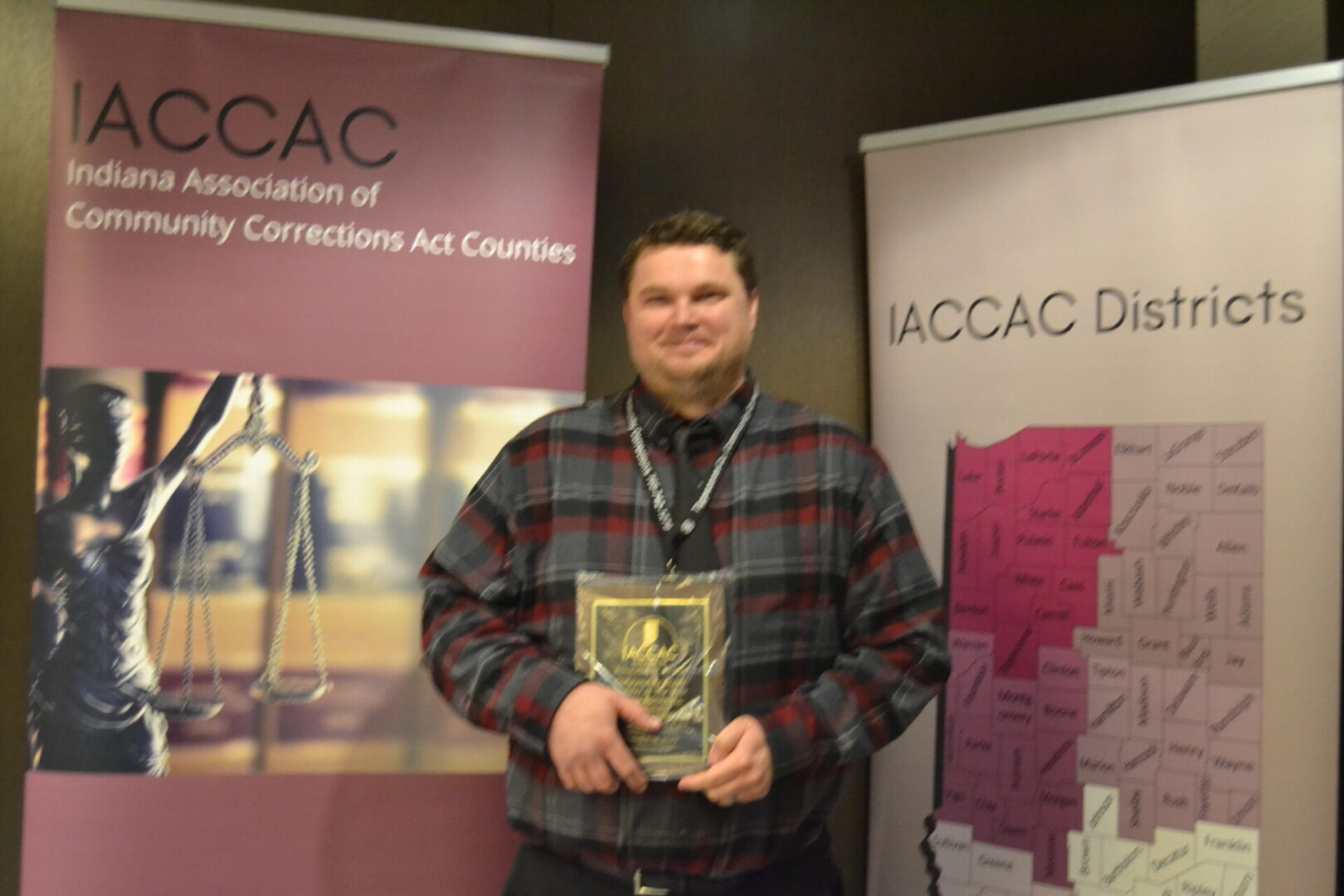 A man holding a book in front of a banner.